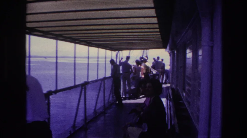 The 1967 Ottawa home-movie frame shows a shaded boat walkway, passengers at the railing, and water visible beyond the deck.