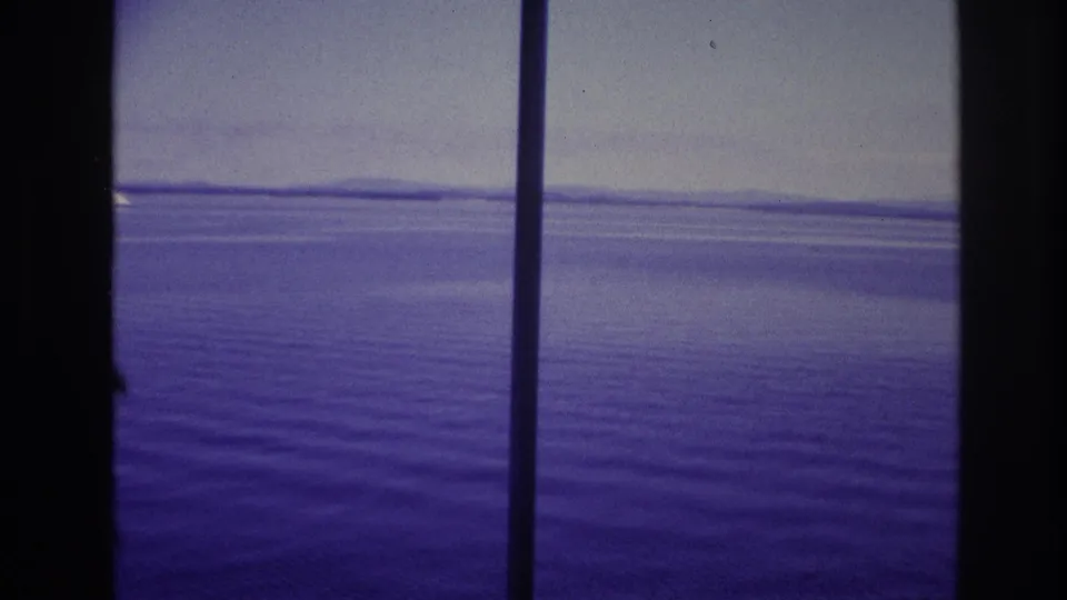 End frame of the 1967 home movie showing open water through ship-deck supports with a purple-blue cast.