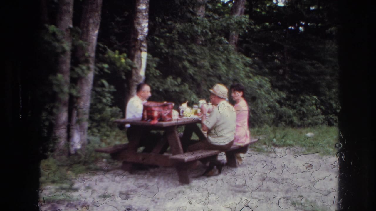 At the end of the clip, three adults sit at the wooden picnic table in the 1967 Ottawa home-movie scene, partly softened by film wear.