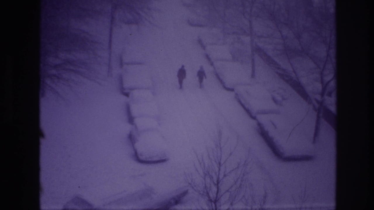 Distant pedestrians walk through a snowy Ottawa street scene from 1967, with cars buried under snow and bare trees nearby.