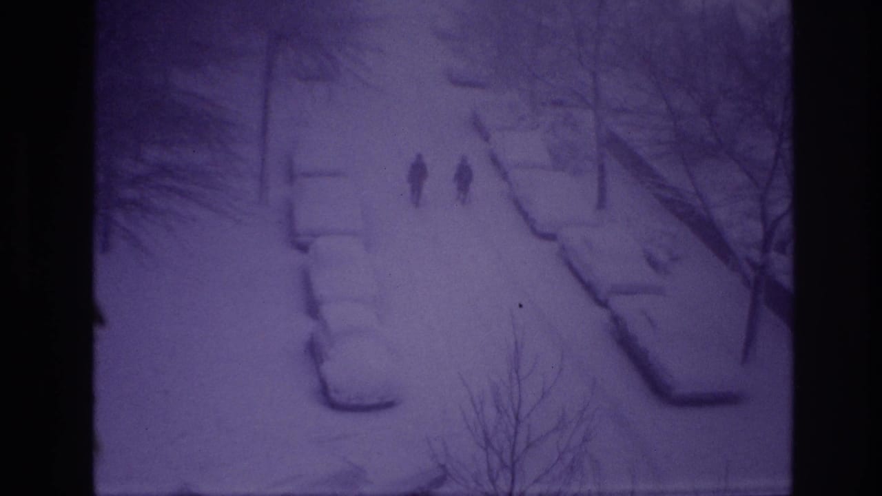 Purple-shifted 8mm frame from Ottawa showing two distant walkers on a snow-covered residential street at night.