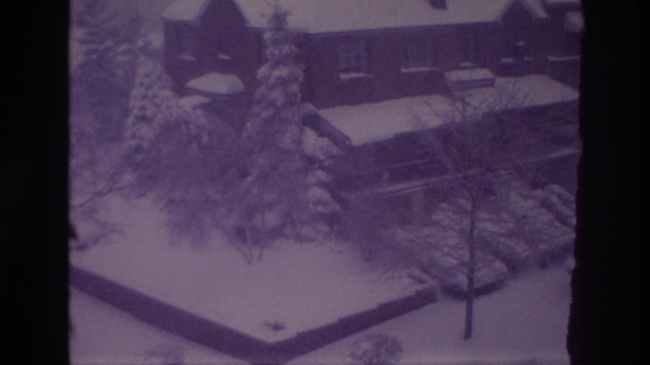 Elevated Ottawa winter view from 1967 showing residential buildings, snowy roofs, trees, and parked vehicles under snow.