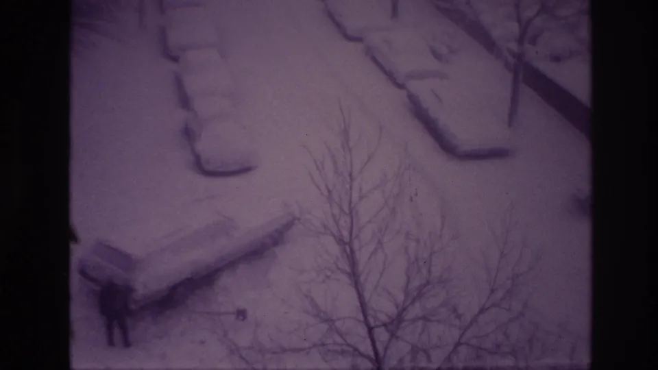 Elevated 1967 Ottawa winter frame showing a distant man in dark clothing beside a snow-covered parked car.