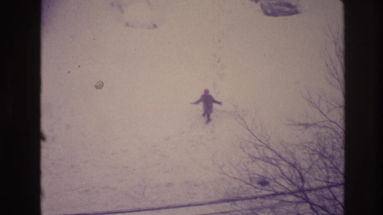 1967 Ottawa 8mm frame looking down at a distant person in snow, with footprints, bare branches, and soft faded color.