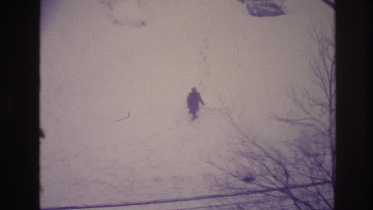 Faded 8mm Ottawa winter frame showing a distant person walking through snow with footprints trailing behind.