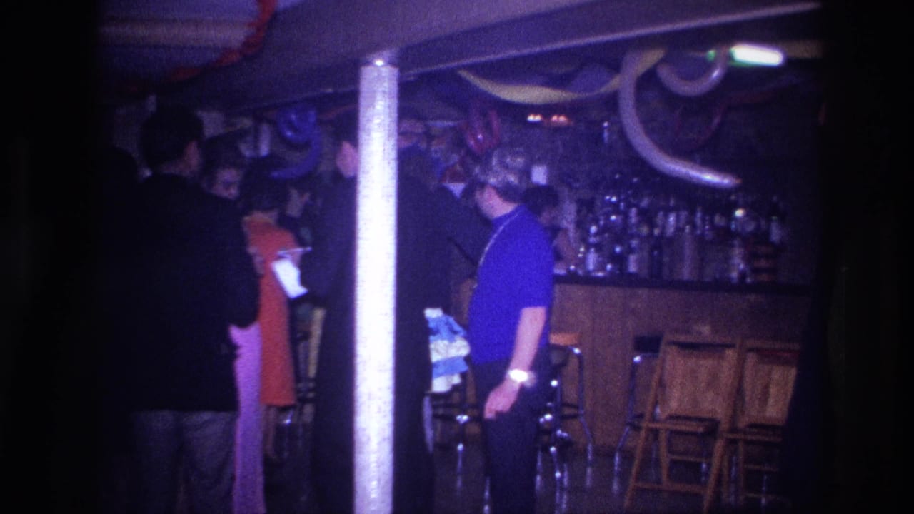 Ottawa 1967 home-movie frame showing adults in a decorated bar or lounge with balloons, streamers, stools, and bottles visible.