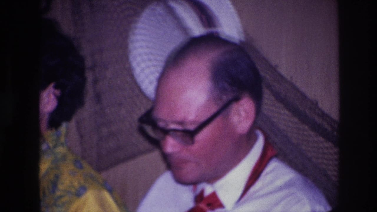 1967 Ottawa frame with a man in a white shirt and red tie seated beside a woman at a restaurant table.