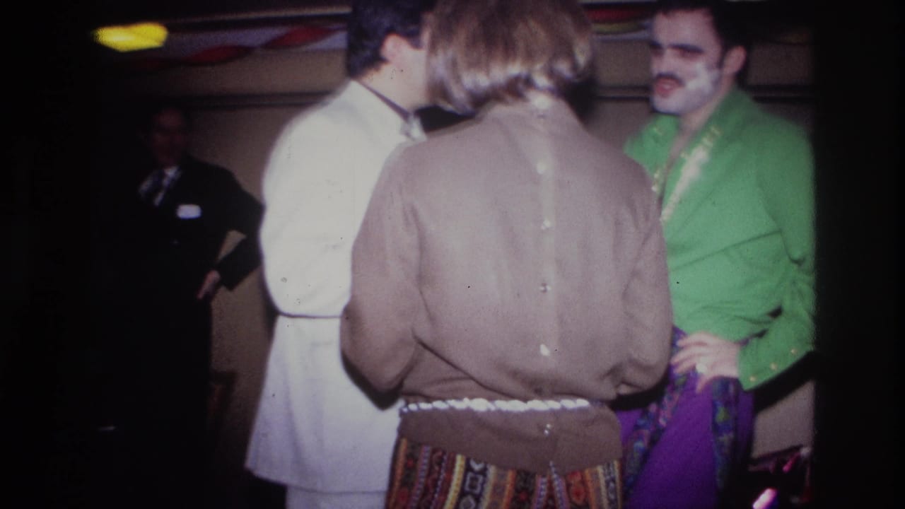 In Ottawa, Canada in 1967, adults gather at a dim private party, including a man in a green shirt, a person in a brown sweater, and a white suit.
