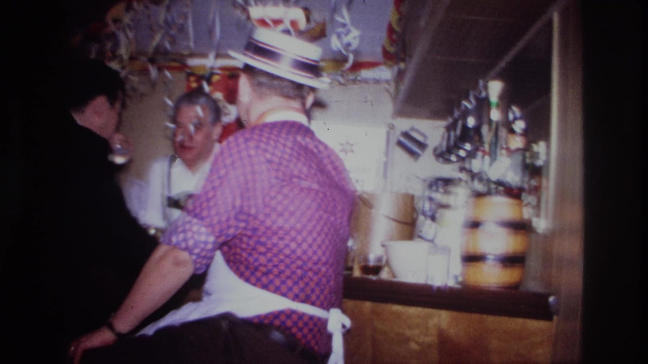 1967 Ottawa home-movie frame showing adults at a decorated bar, with aprons, drinks, streamers, and a small barrel visible.