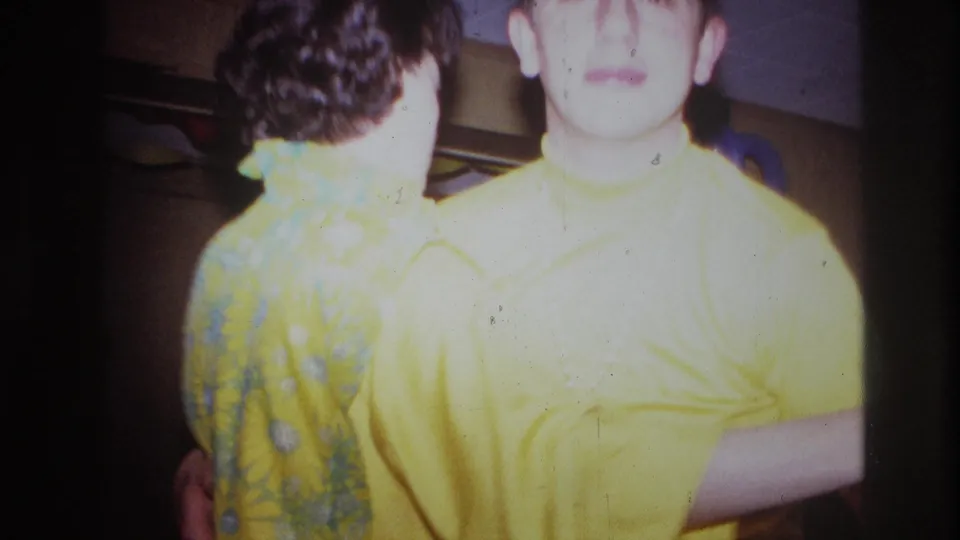 1967 Ottawa home-movie frame of a dancing couple close to the camera, with one face overexposed and party decorations partly visible.