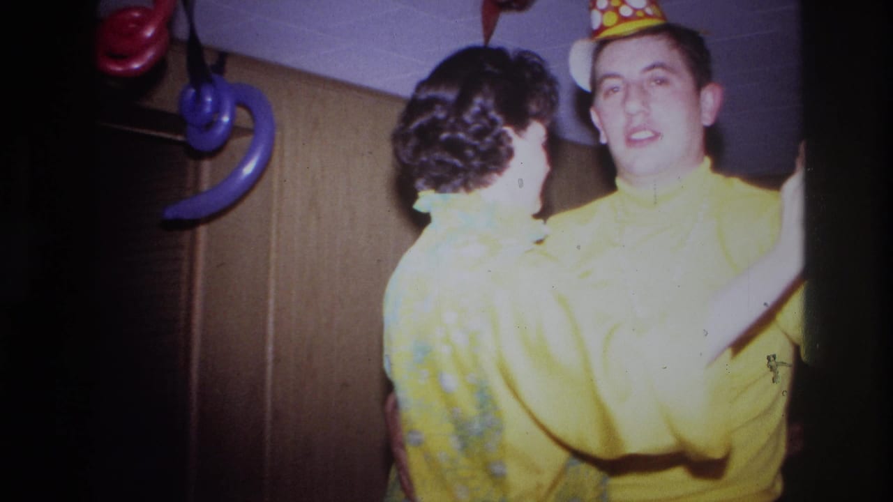 The couple turns while dancing at the Ottawa birthday party, with the man's polka-dot hat and the woman's curled hair visible.