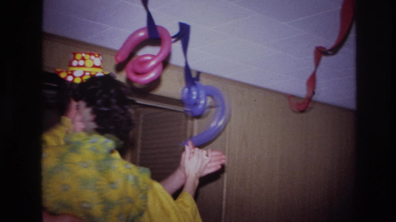 The couple turns while dancing in a decorated Ottawa interior, with balloon shapes, streamers, and a louvered door behind them.