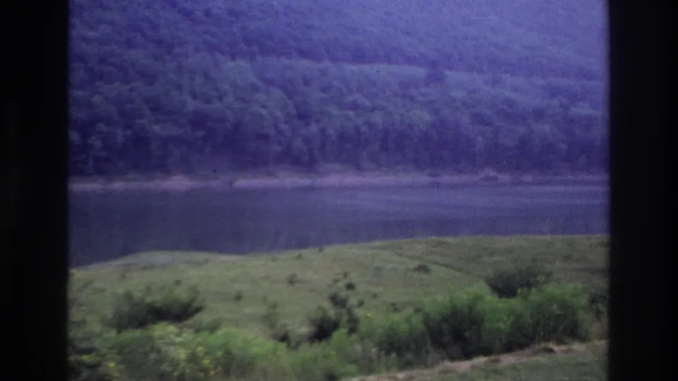 The final frame shows a quiet 1967 Ottawa-area lake or river landscape, framed by dark borders and softened by aged 8mm color.