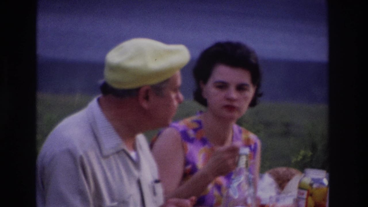 1967 Ottawa picnic frame with a woman gesturing during conversation beside a man in a light shirt and yellow beret.