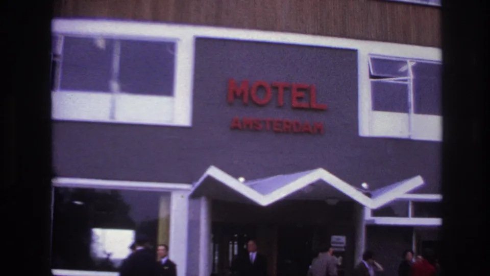 The final frame shows the Motel Amsterdam sign above a modern entrance, with several adults gathered near the doorway in the 1967 Paris footage.