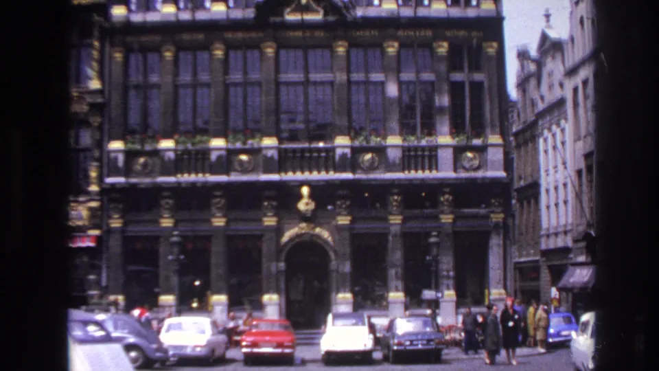 1967 Paris street view showing an ornate historic facade, parked period cars, and pedestrians near the entrance.