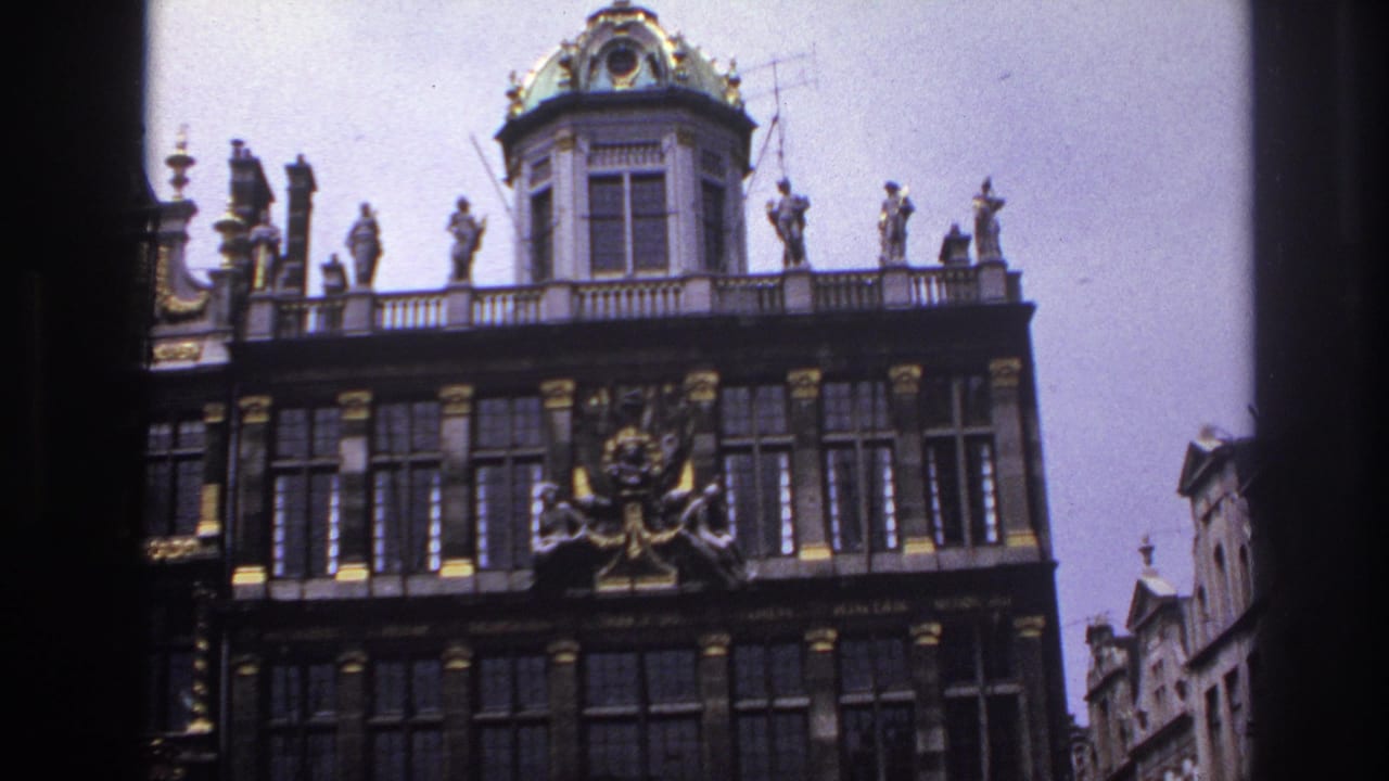 Upper facade with a green-tiled dome, rooftop statues, and gilded trim.