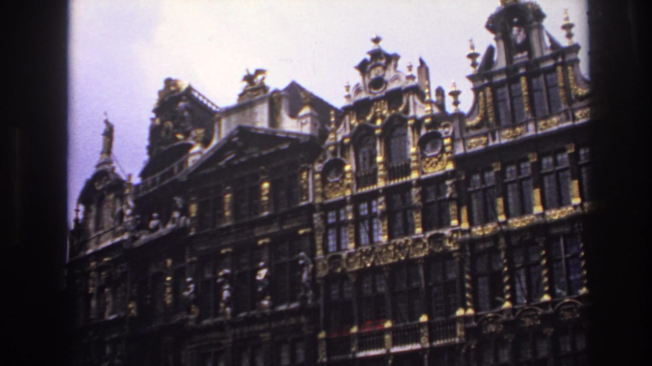 Historic gabled facades with gilded ornament and tall windows against pale sky.