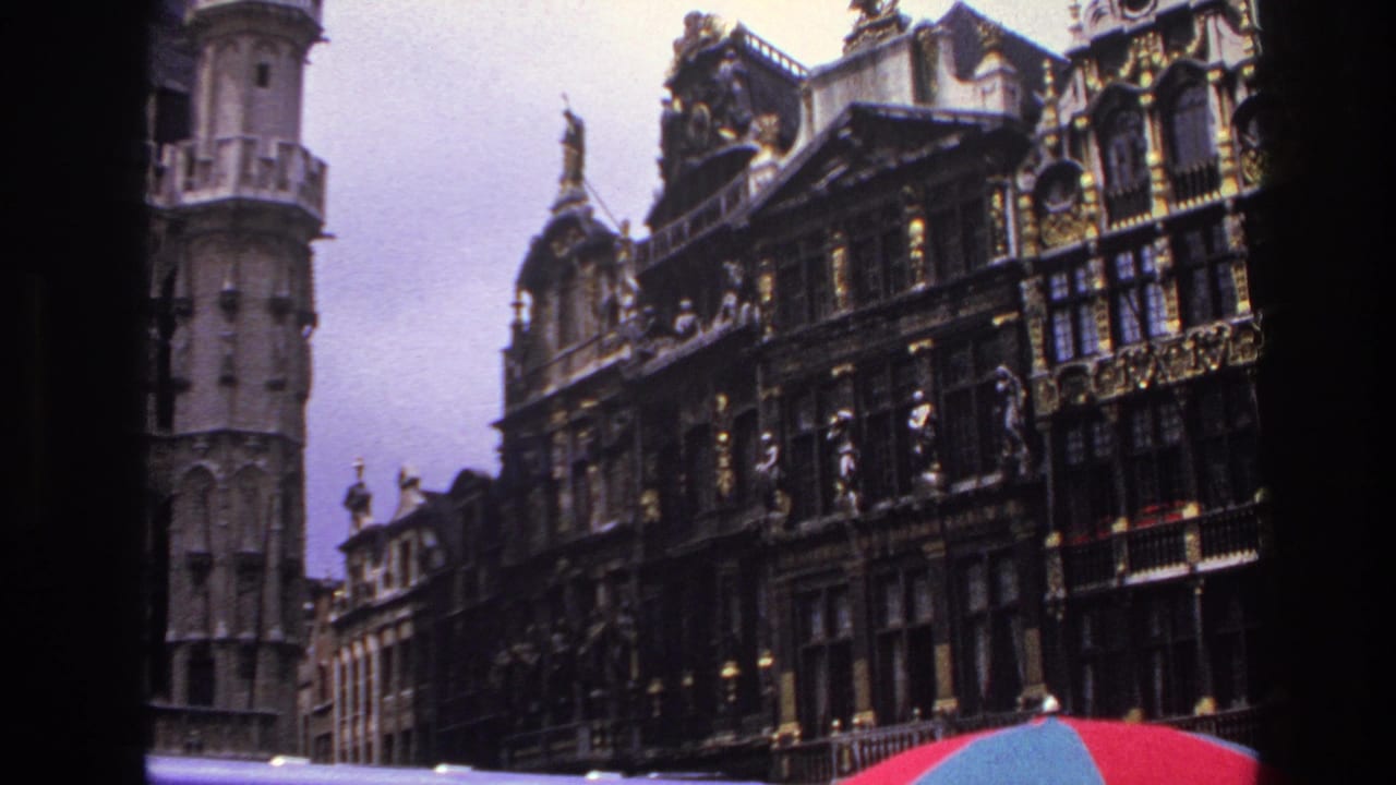 1967 Paris frame with ornate historic buildings, gilded decorative details, rooftop figures, and a red-blue umbrella crossing the bottom edge.
