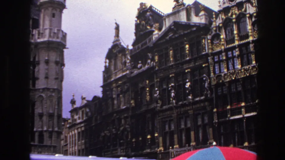 1967 Paris frame with ornate historic buildings, gilded decorative details, rooftop figures, and a red-blue umbrella crossing the bottom edge.