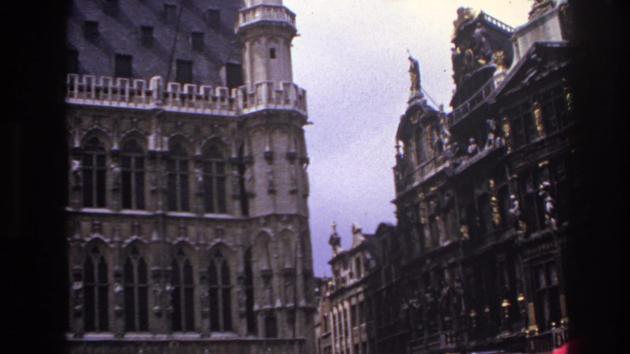 1967 Paris travel footage showing ornate historic facades, arched windows and a neighboring decorated building under an overcast sky.