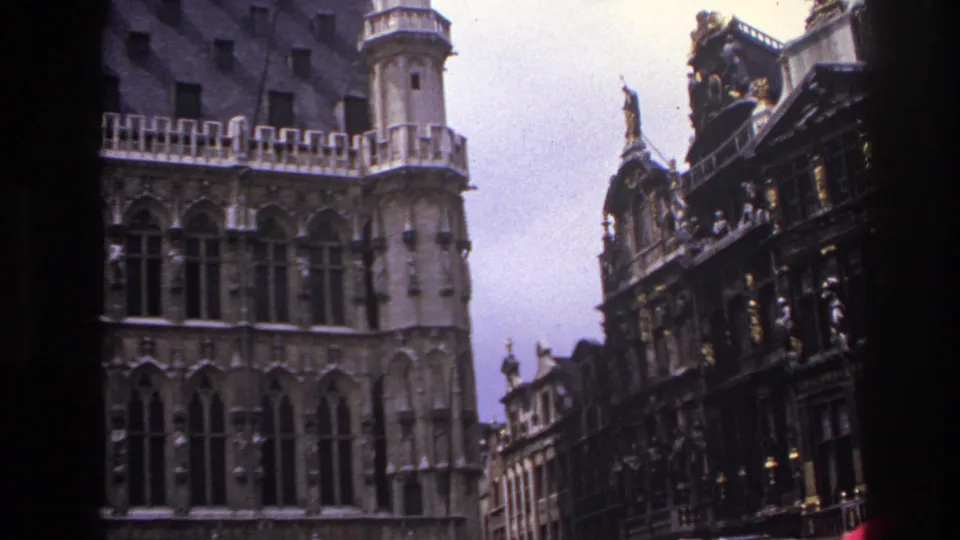 1967 Paris travel footage showing ornate historic facades, arched windows and a neighboring decorated building under an overcast sky.