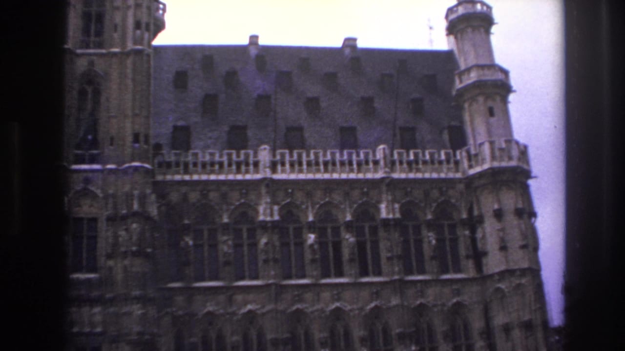 Central tower and long roofline of an ornate stone building.