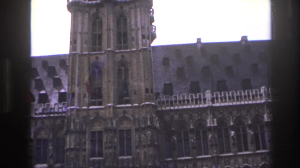 Final 1967 Paris frame with tower masonry, pointed window openings, roof tiles, and a dark foreground edge from the filming position.