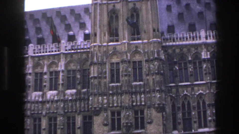 1967 Paris exterior view of a Gothic-style facade with arched windows and a small flag above the stonework.