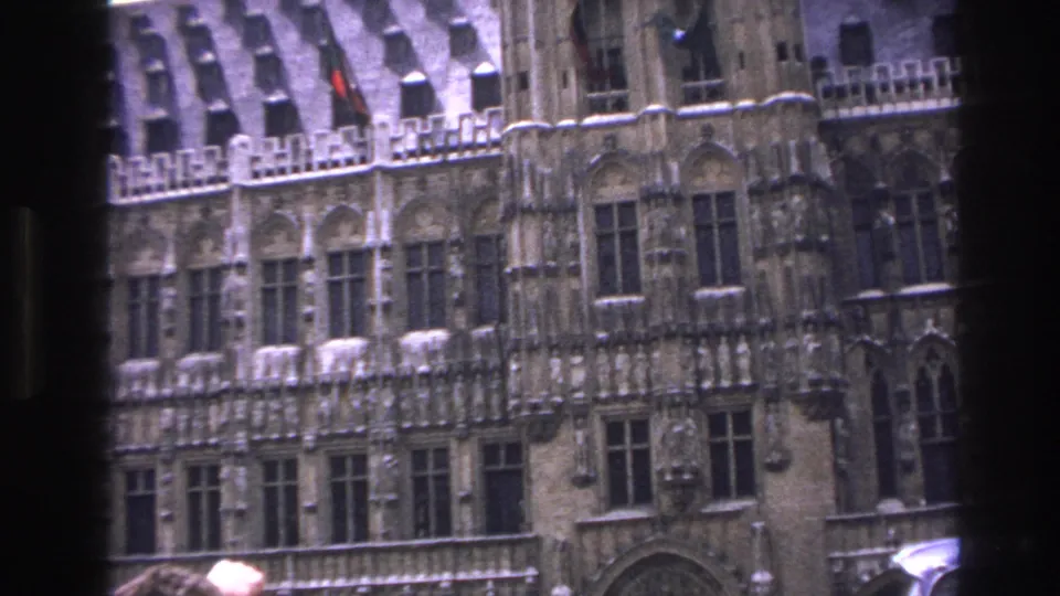 1967 Paris home-movie frame with a closer look at decorative stonework and arched windows behind a window divider.