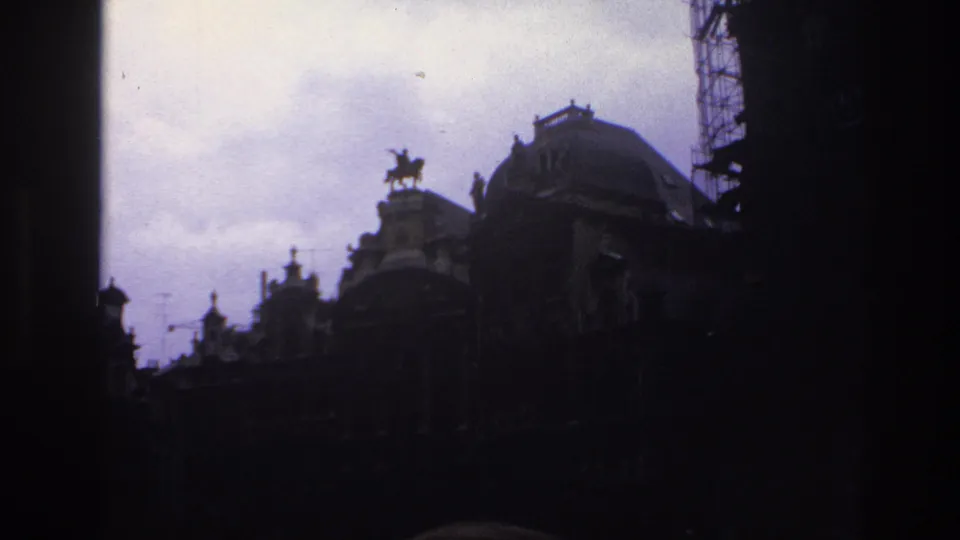1967 Paris street-level view of historic rooftops, a domed structure, equestrian statue, scaffolding, and washed-out cloudy sky.