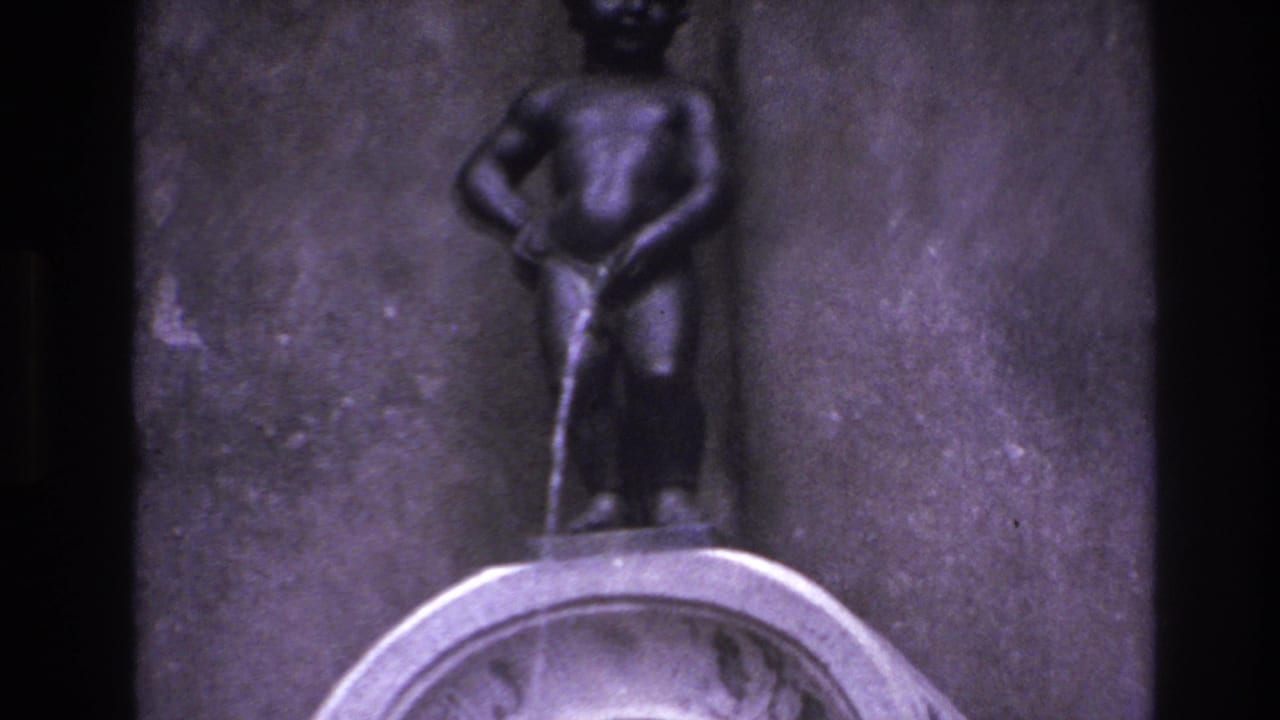 Small fountain statue centered above a rounded stone basin, with water streaming downward.