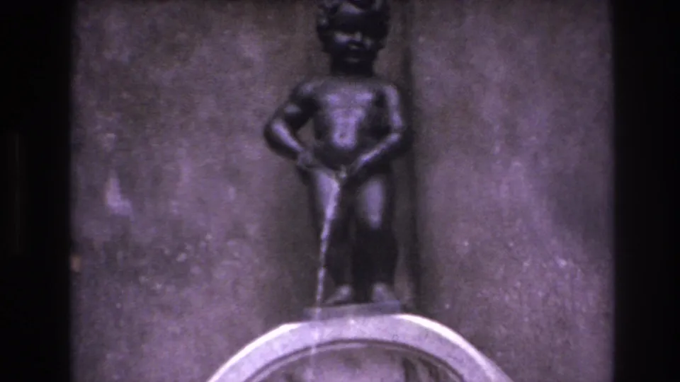 Final 1967 8mm frame holds on the small boy-like fountain statue, basin rim, and textured stone wall.