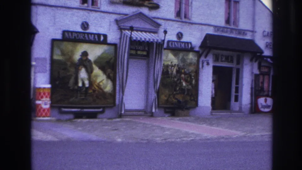 1967 Paris cinema exterior with large Naporama and other film posters, a cinema entrance, cafe signage, and a beer advertisement.