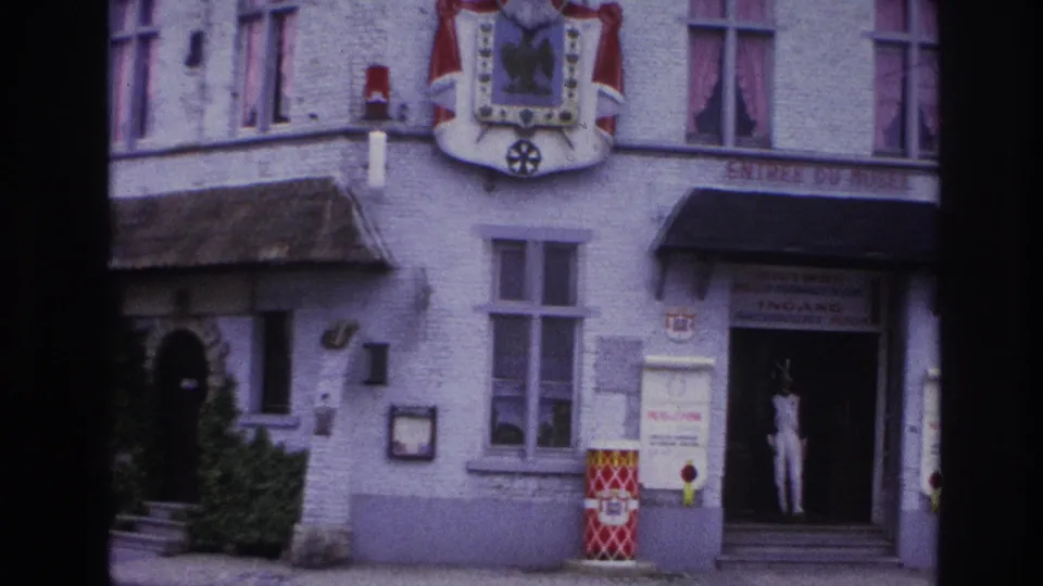 1967 Paris frame with the museum entrance partly to the right, a uniformed mannequin in the doorway, facade windows, and an arched side door.