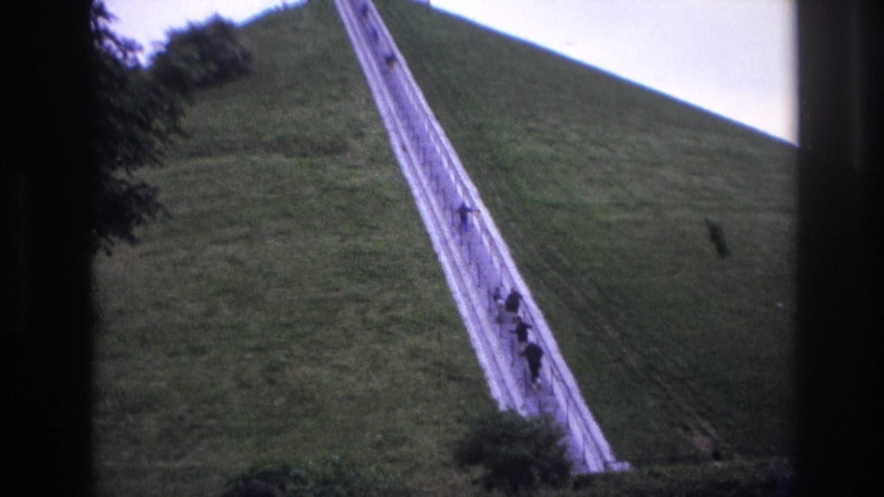 1967 8mm travel footage shows a steep grassy mound with visitors ascending a long stairway toward a monument above.