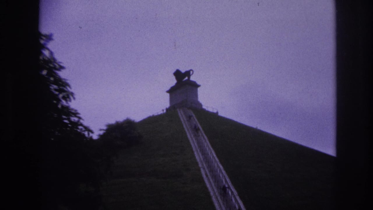 1967 Paris home-movie frame showing distant visitors climbing a steep hillside stairway toward a silhouetted lion statue.