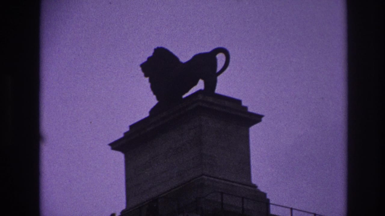 1967 Paris frame with the lion statue centered high on its pedestal, rendered as a dark silhouette against tinted sky.