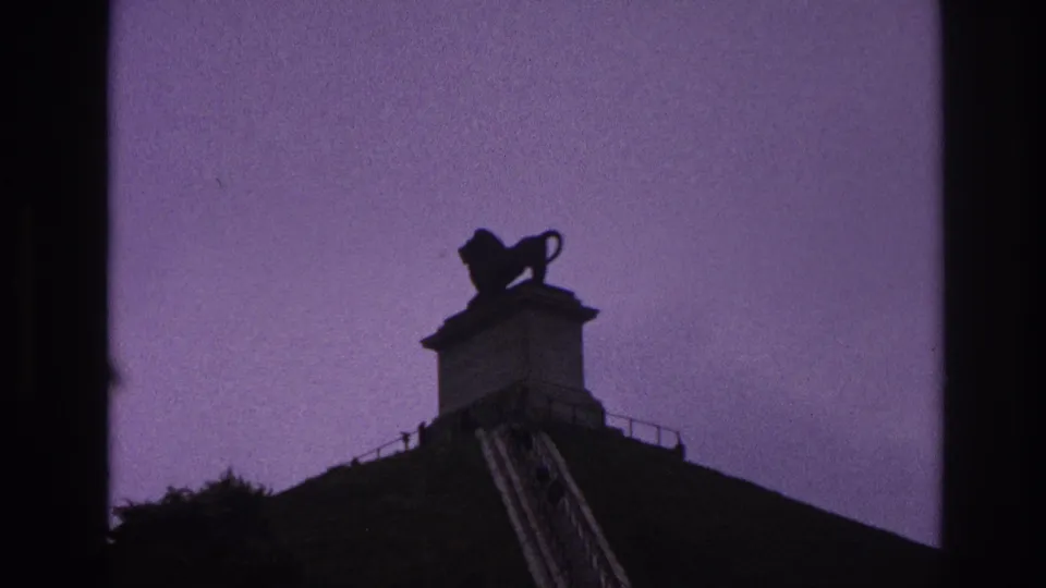 1967 Paris home-movie view of a lion statue on a high pedestal, with stairs rising up the hillside.