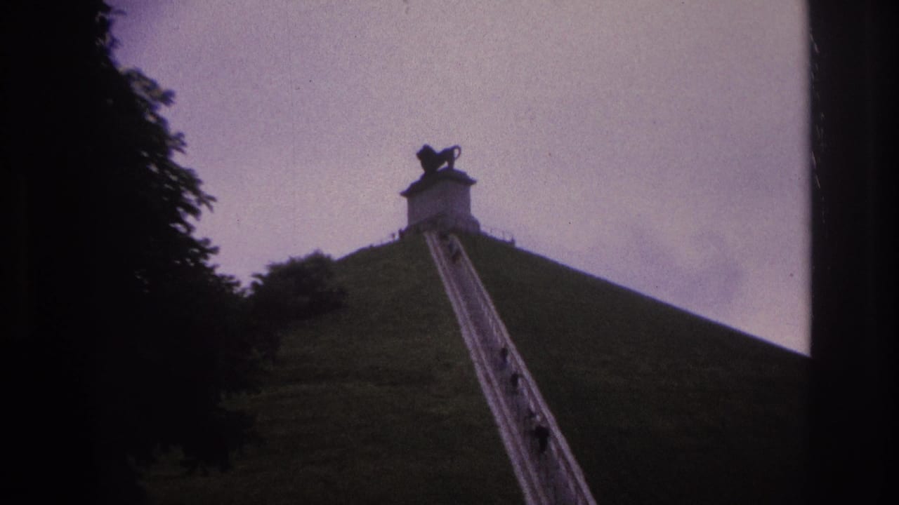 Long stairway on a steep green hill with small people climbing toward a top monument.