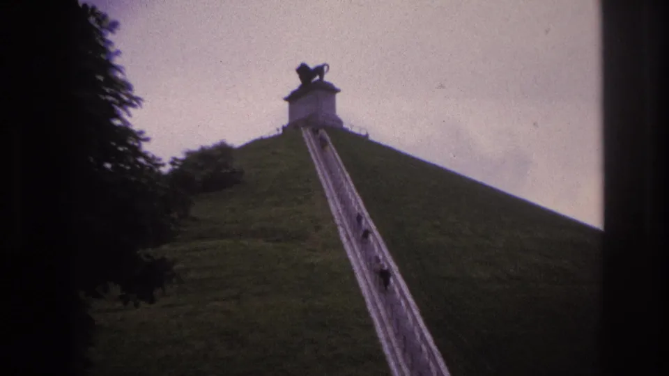 1967 Paris 8mm frame with a low upward view of people climbing a long stairway on a grassy hillside.