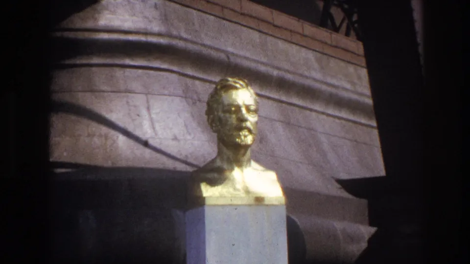 1967 Paris travel-film frame with a closer view of the reflective golden bust against curved stonework and deep shadows.