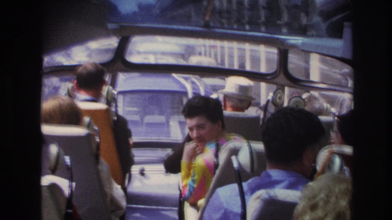 1967 Paris bus interior with adult passengers seated and a woman in a bright patterned dress smiling toward the camera.