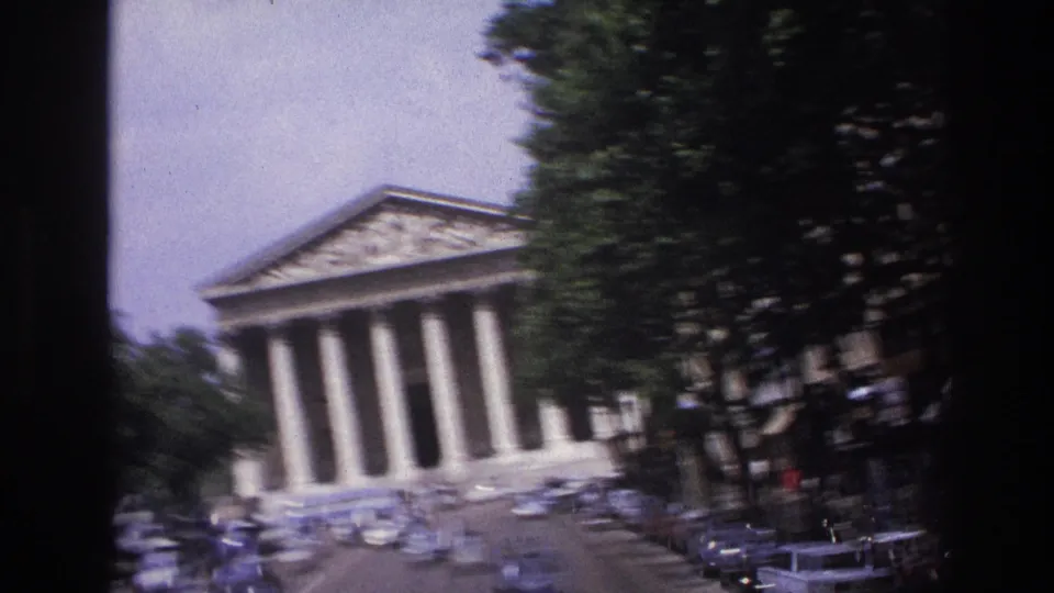 1967 Paris frame softened by motion, showing the Panthéon, roadside trees, cars, and a busy approach street.