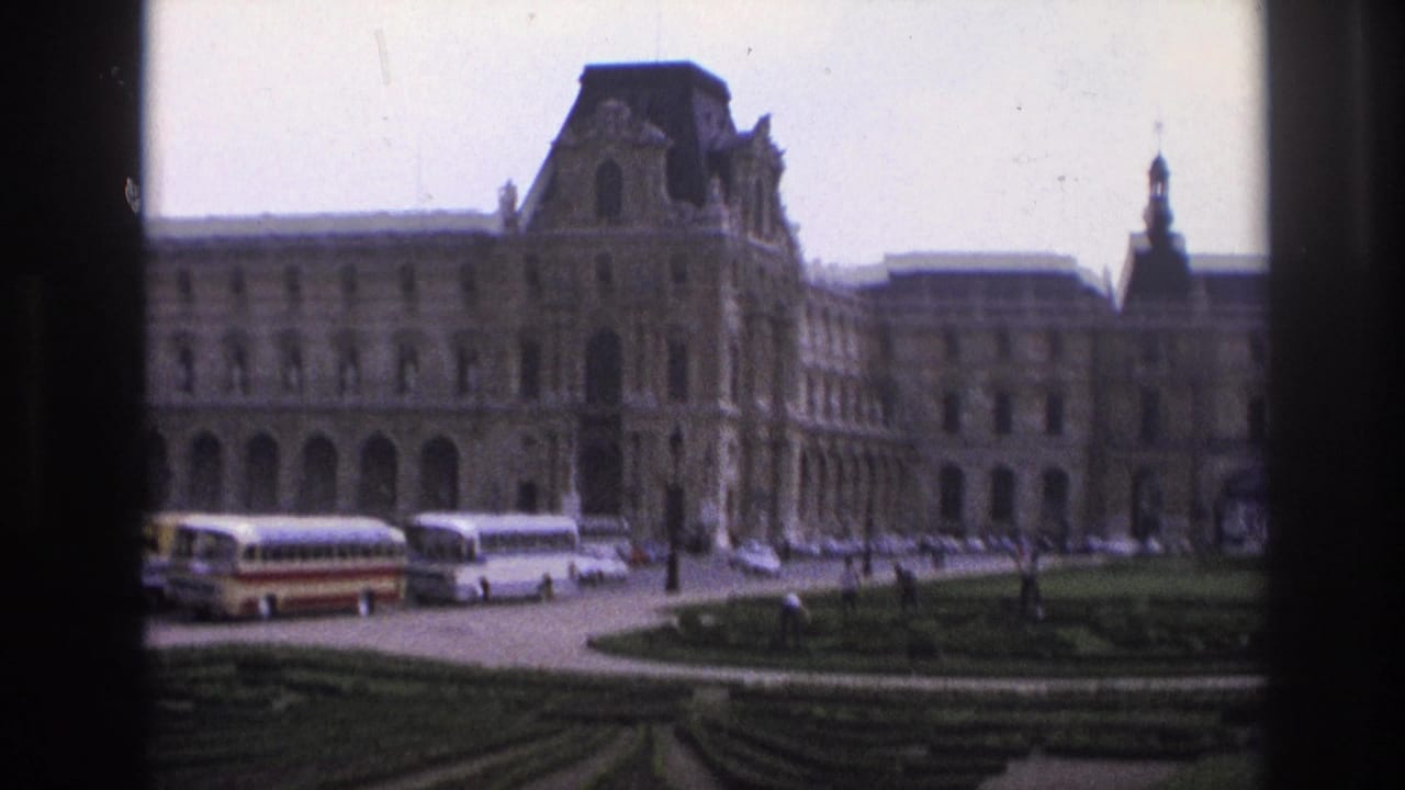 1967 Paris home-movie view of the Louvre exterior, tour buses, parked cars, garden paths, and dark vertical framing.