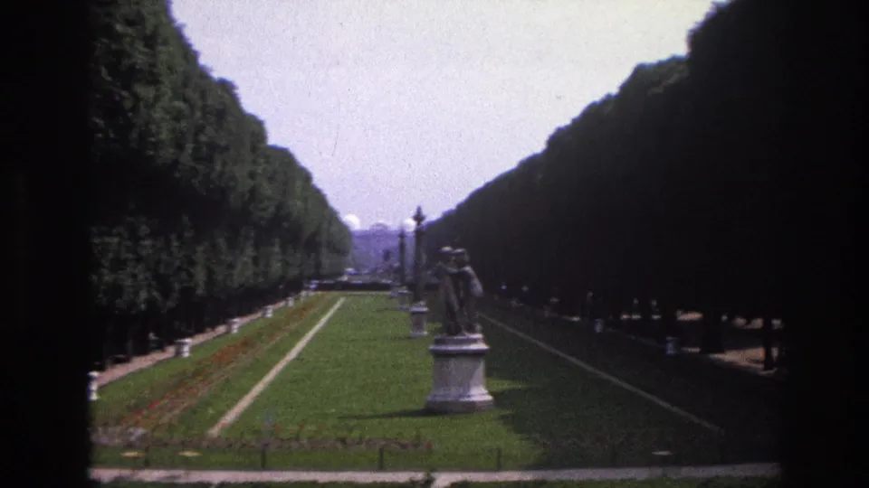 1967 Paris footage shows the formal garden from a similar angle, with the statue, hedges, lawn borders, and lampposts still visible.