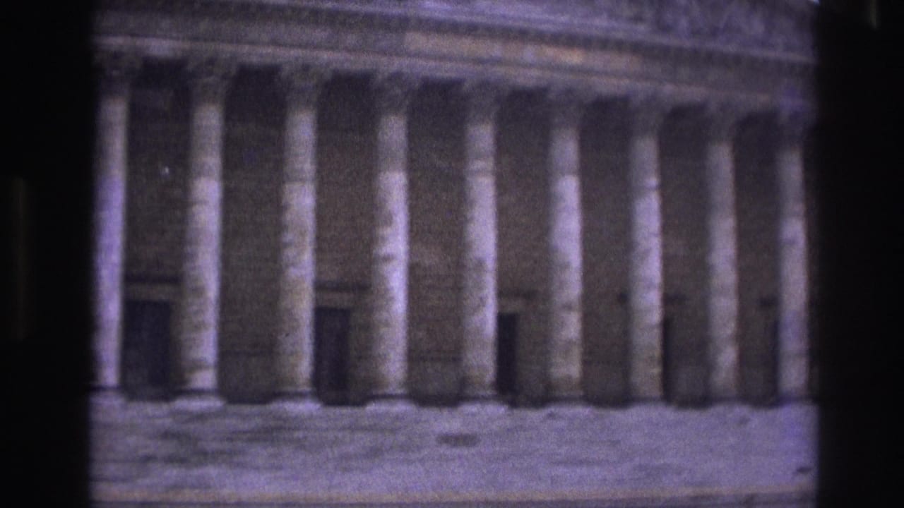 1967 Paris home-movie view of a neoclassical facade with tall columns, partly obscured by dark foreground framing.