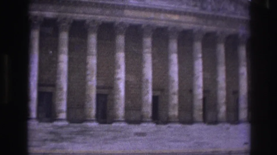 1967 Paris home-movie view of a neoclassical facade with tall columns, partly obscured by dark foreground framing.