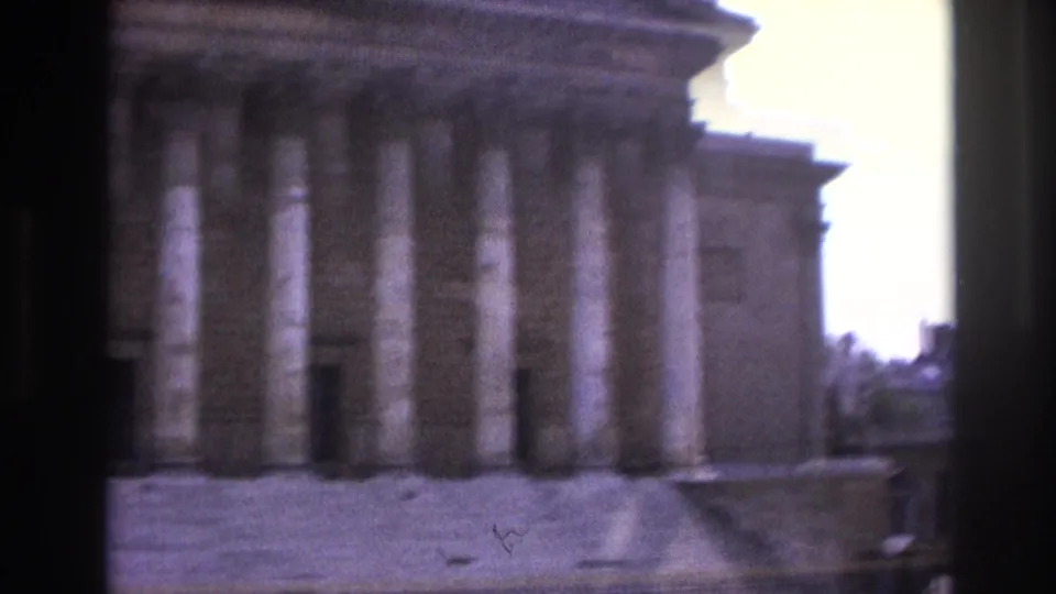 Faded 8mm view in Paris showing a columned facade and roofline, with a dark vertical strip crossing the frame.