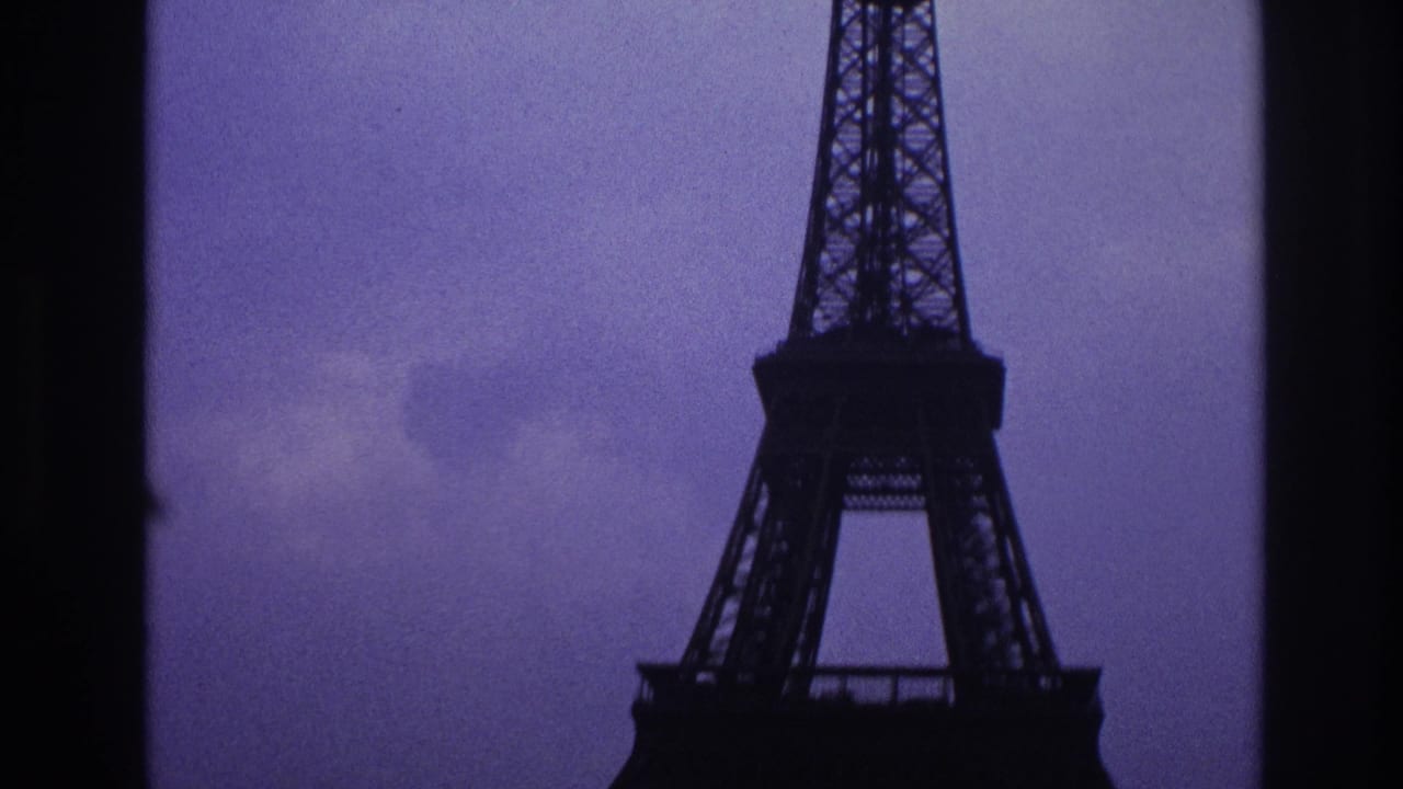 Partial Eiffel Tower structure framed by dark vertical film edges and cloudy sky.